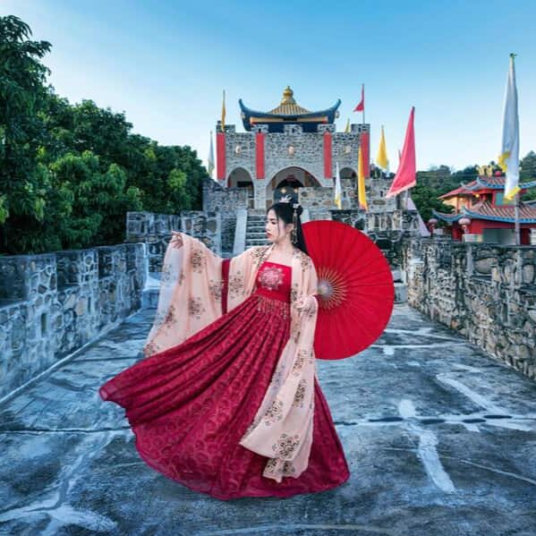 Eine traditionell gekleidete Frau vor einem chinesischen Tempel